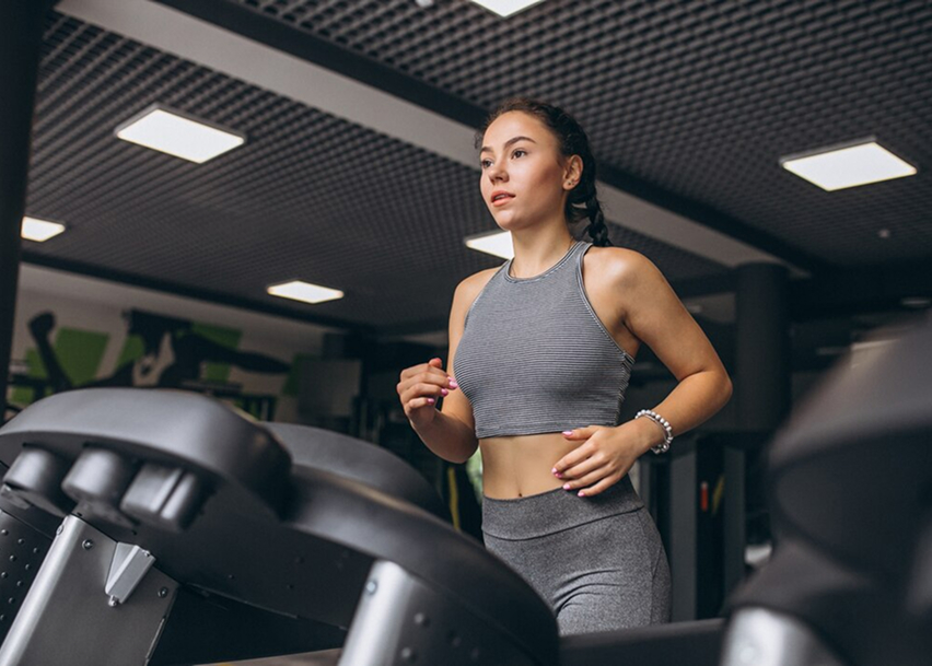 Женщина бежит трусцой на беговой дорожке